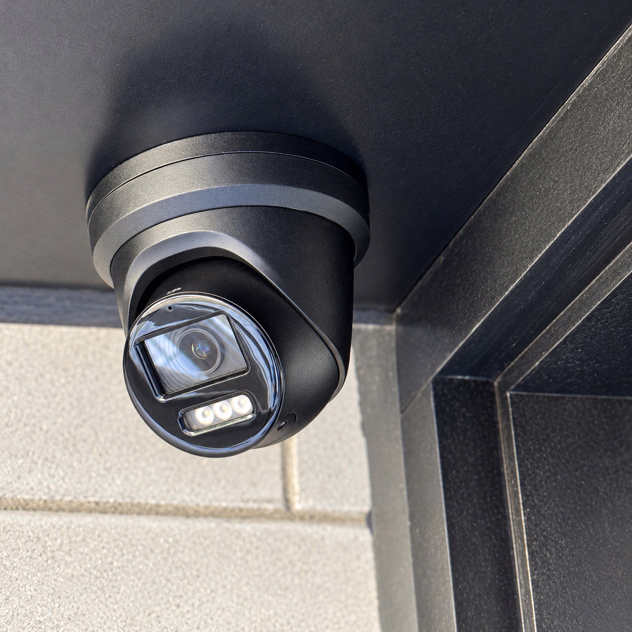 Black commercial security camera mounted beneath a soffit