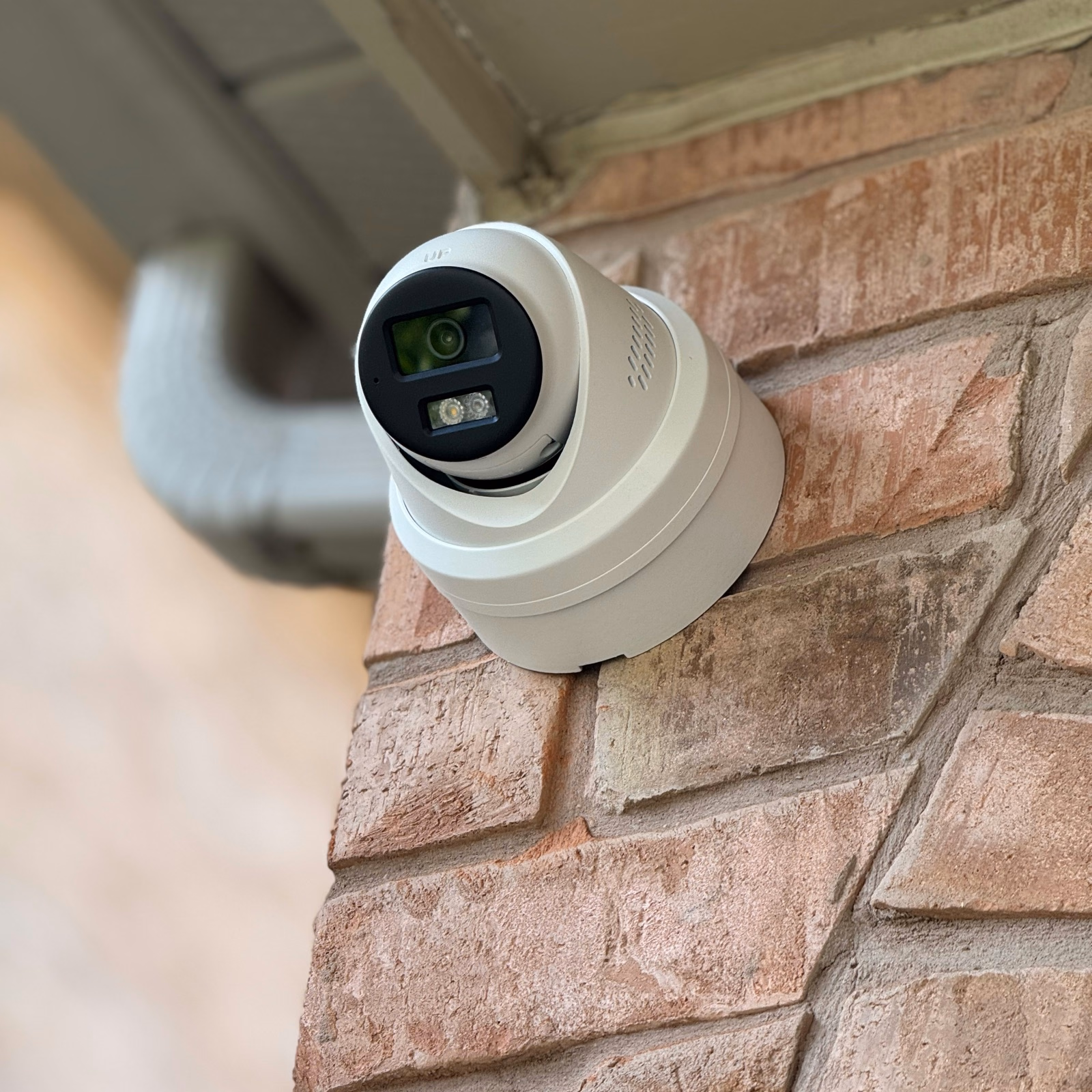 Security camera mounted beneath a house soffit at a brick corner in Etobicoke