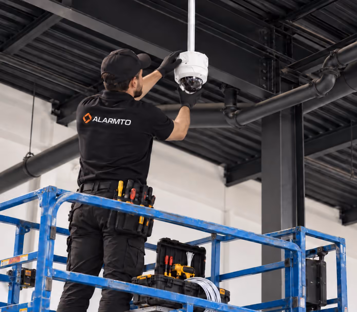 Technician installing a security camera inside a commercial building