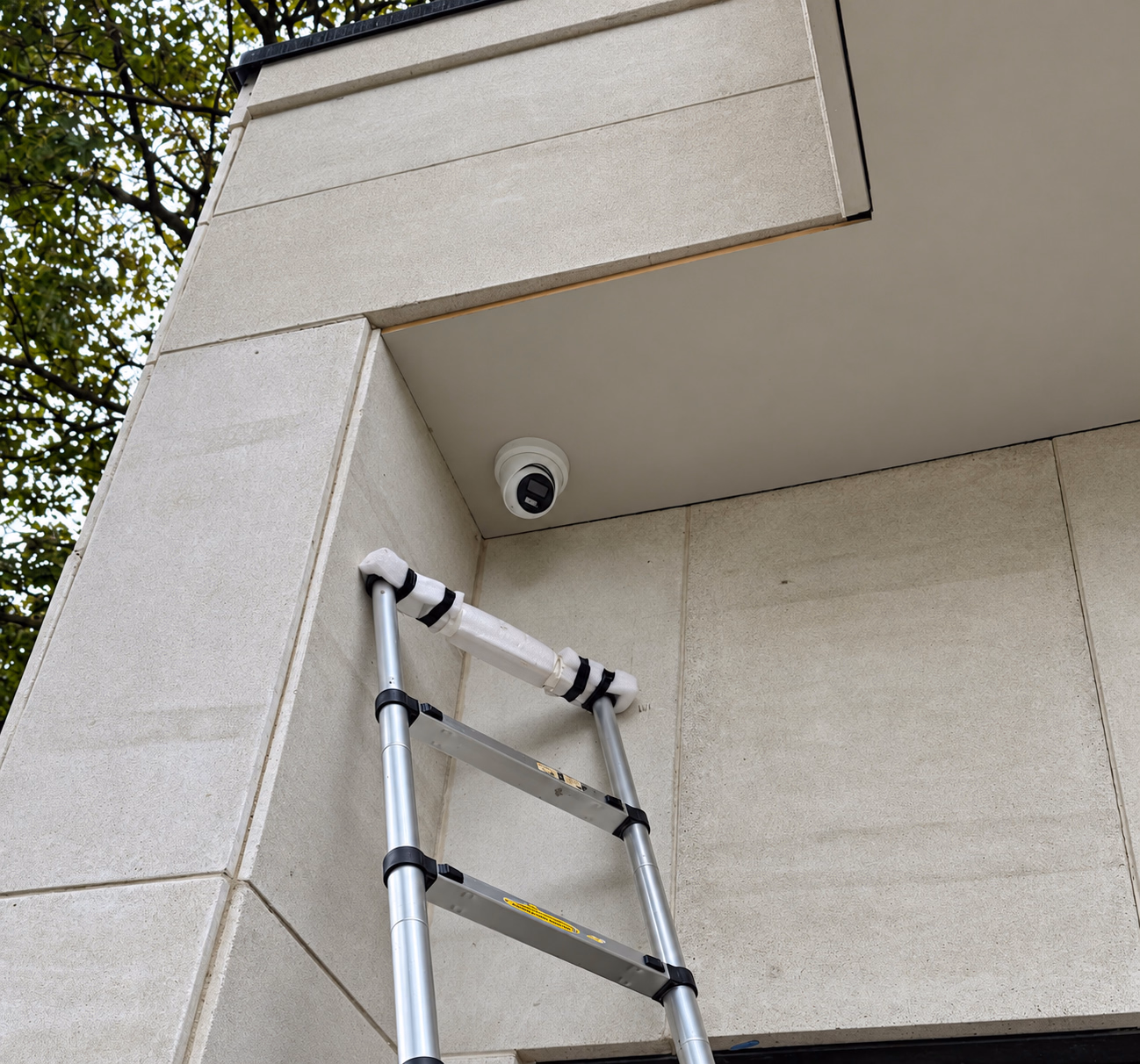 Exterior security camera installed above a ladder